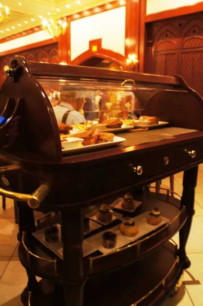 Be Our Guest Rosa magica carrinhos guiados pela Rosa garcons trazem vestidos anos 1400 a 1600 - Onde comer na Disney